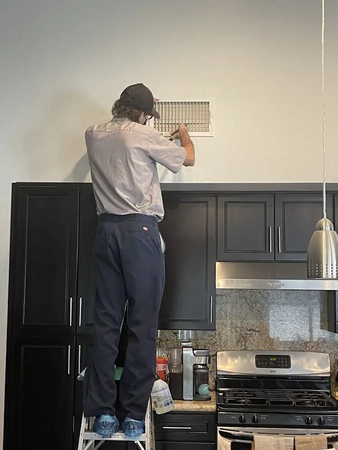 Technician inspecting an air vent during HVAC service in Ceres